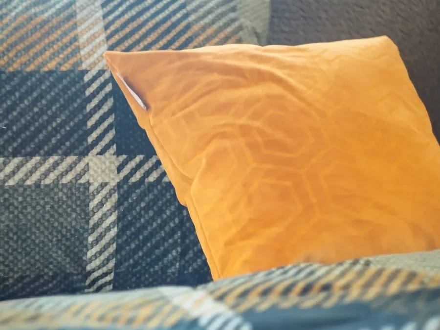 Geruit beddengoed met okerkleurig sierkussen