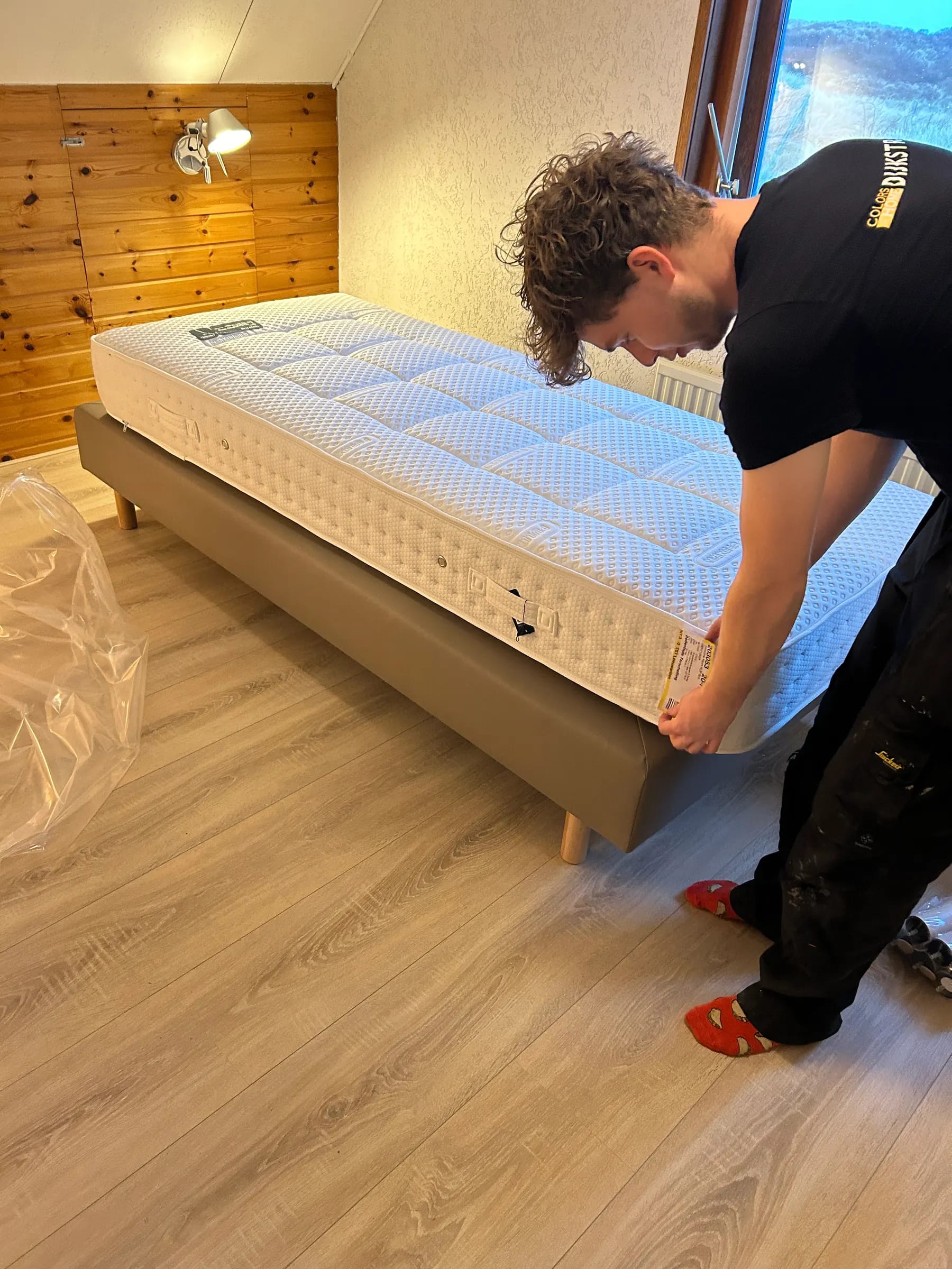 Man_die_het_bed_klaarzet