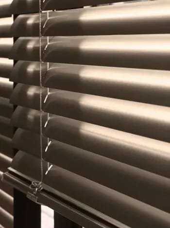 Detail van een bronskleurige aluminium jaloezie.