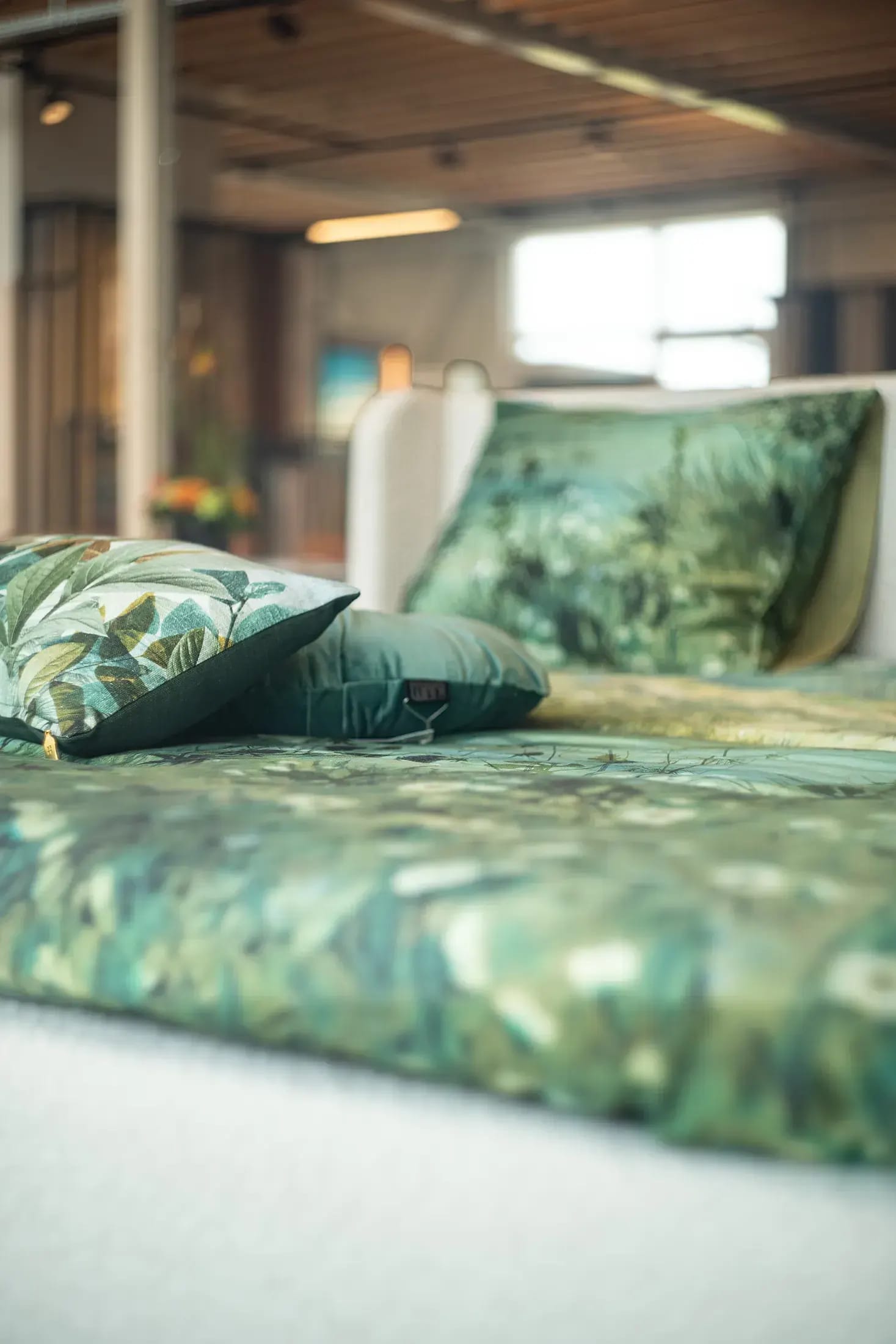 Beddengoed met groen bladmotief in de showroom.