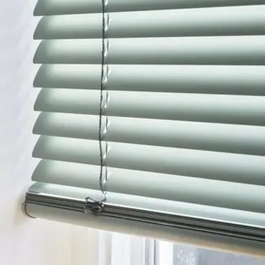 Detail van een groene aluminium jaloezie met ladderband.