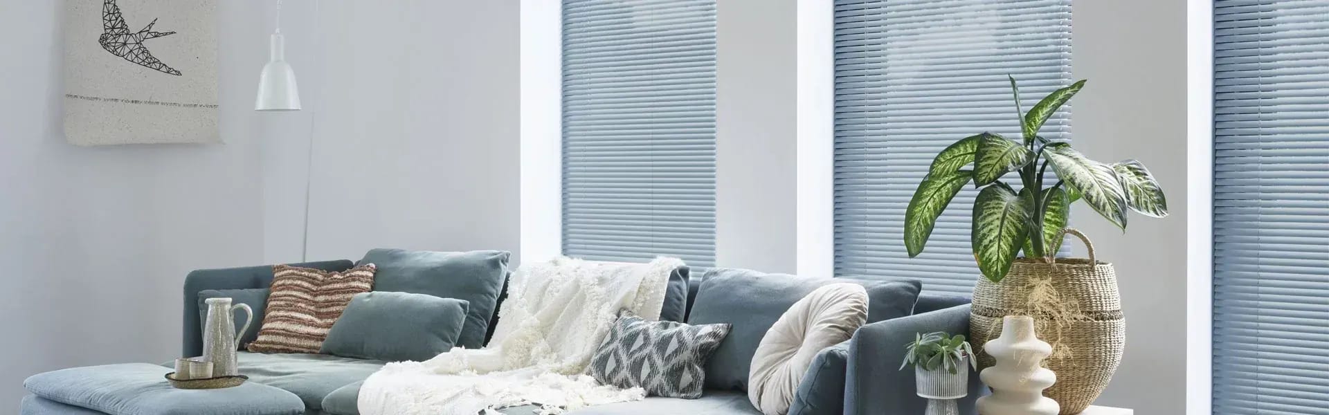 Horizontale jaloezieën voor de ramen van een lichte woonkamer.