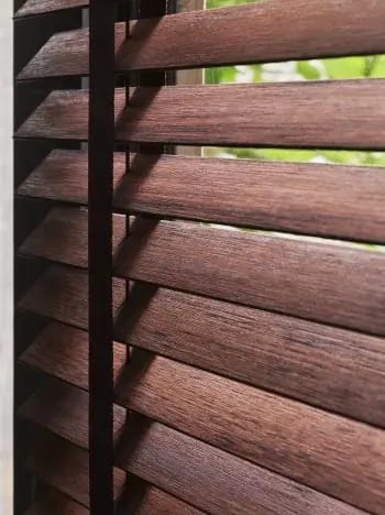 Donkerbruine houten jaloezie met ladderband.