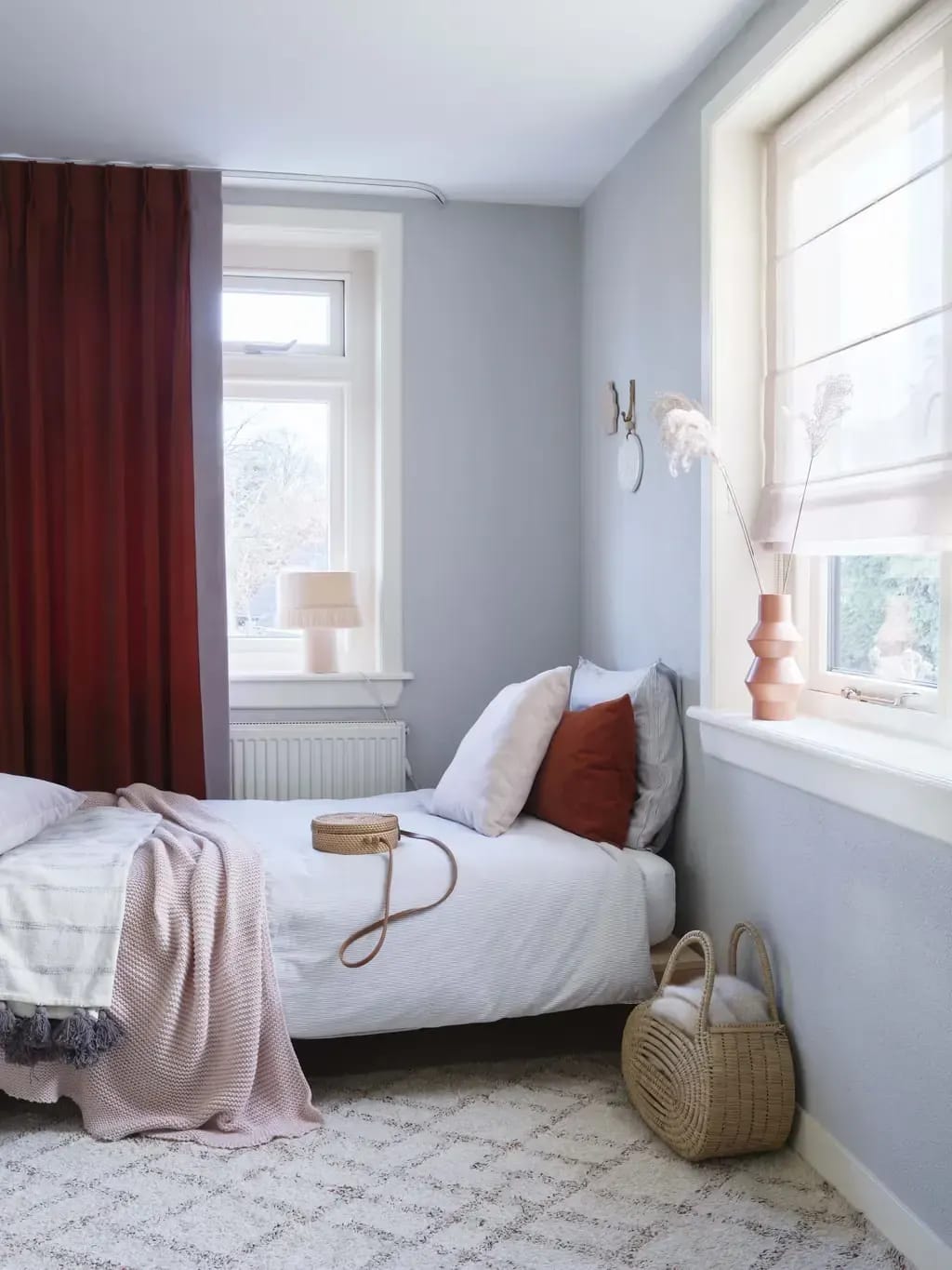 Rode overgordijnen in een lichte slaapkamer.
