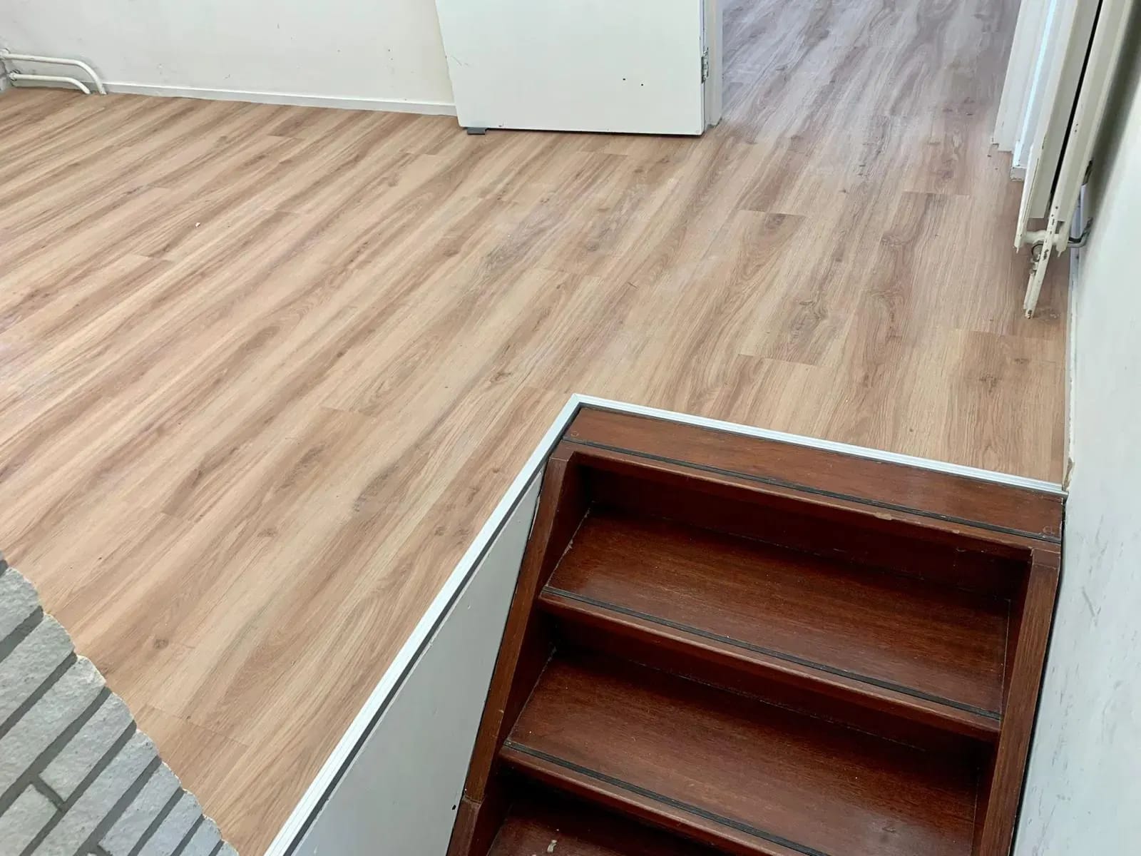 PVC-vloer netjes afgewerkt rond een trapgat.