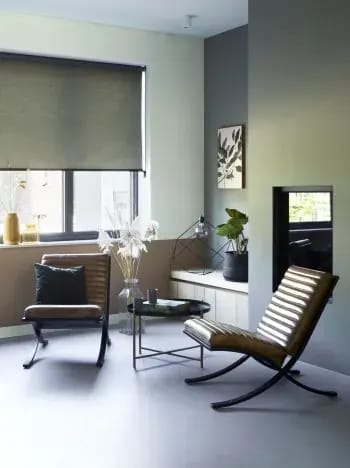 Groen rolgordijn in een zithoek met twee fauteuils.
