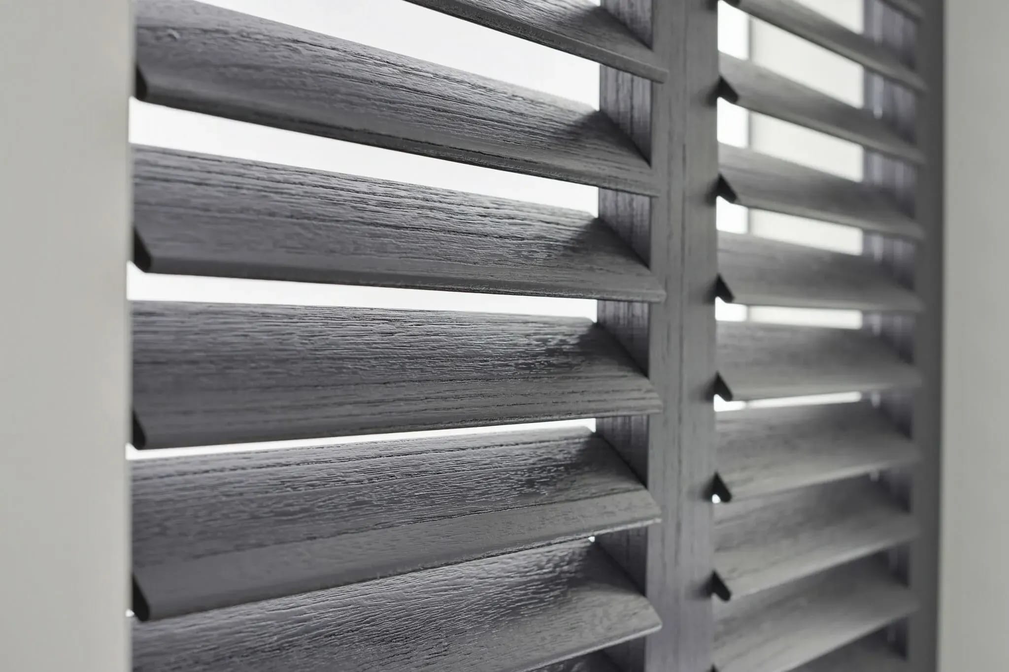 Detail van grijze shutters met houtnerf.