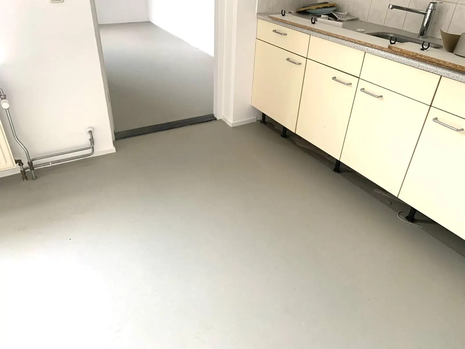 Lichtgrijze vinylvloer in een keuken.