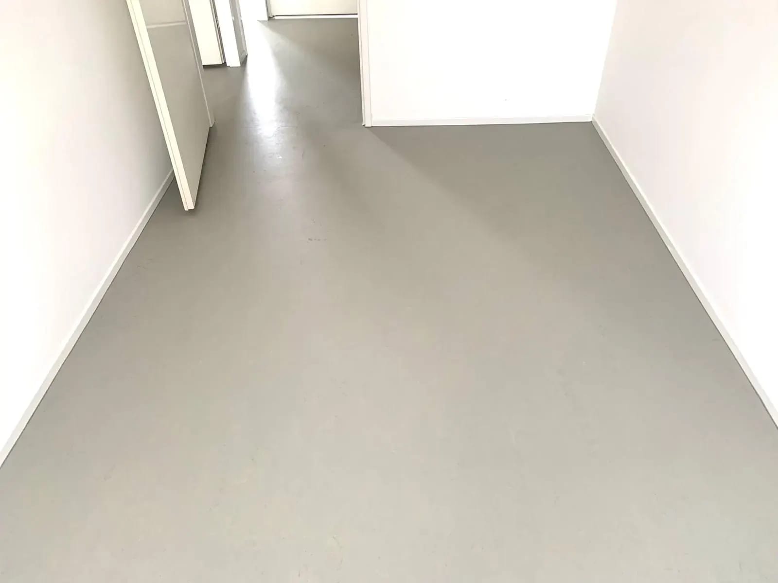 Lichtgrijze vinylvloer op een overloop.