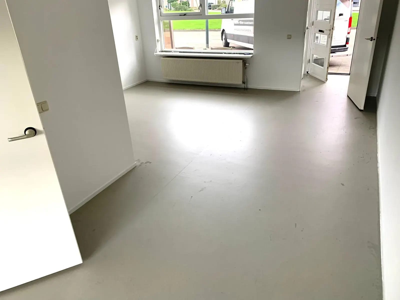Lichtgrijze vinylvloer in een lichte woonkamer.