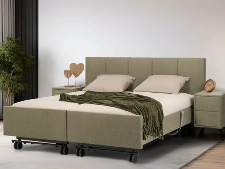 Tweepersoons zorgbed in groene stof met gestoffeerd hoofdbord.