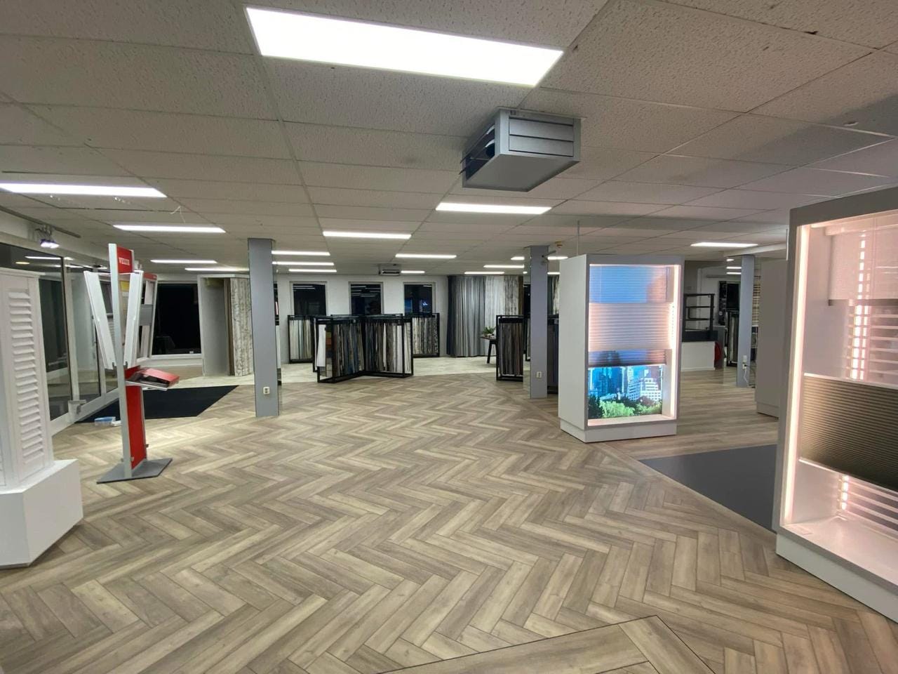 Interieur van de gemoderniseerde showroom met ledverlichting en vernieuwde vloeren.