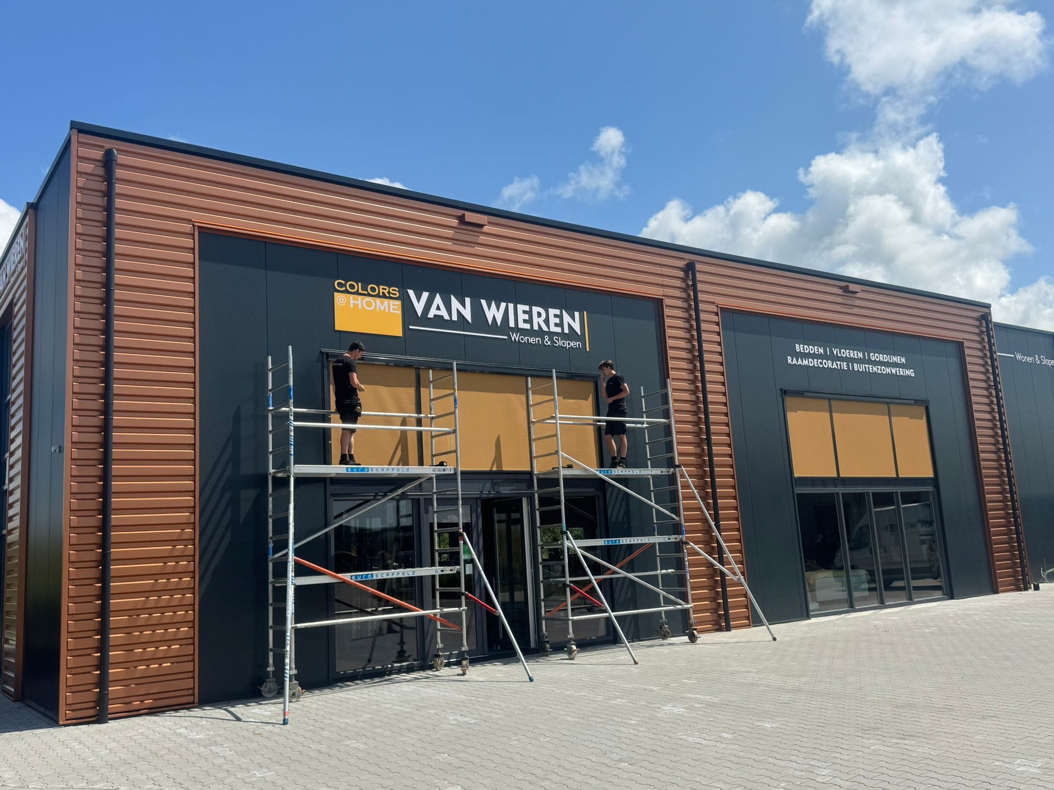 Monteurs plaatsen solar screens op de gevel van ons pand in Franeker.