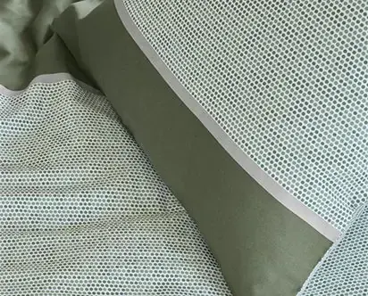 Detail van een groen dekbedovertrek met stippen.