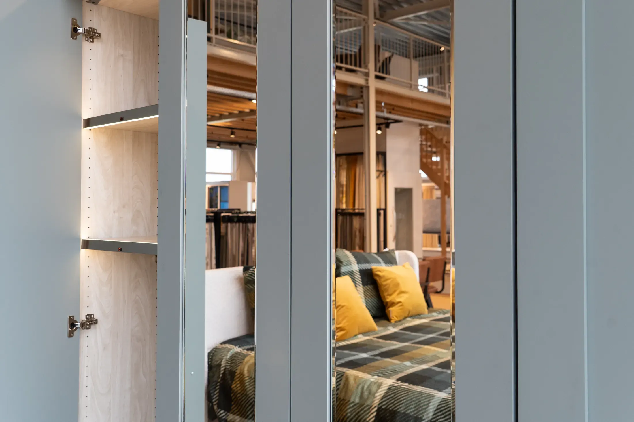 Linnenkast met een openstaande deur en spiegeldeuren in de showroom.