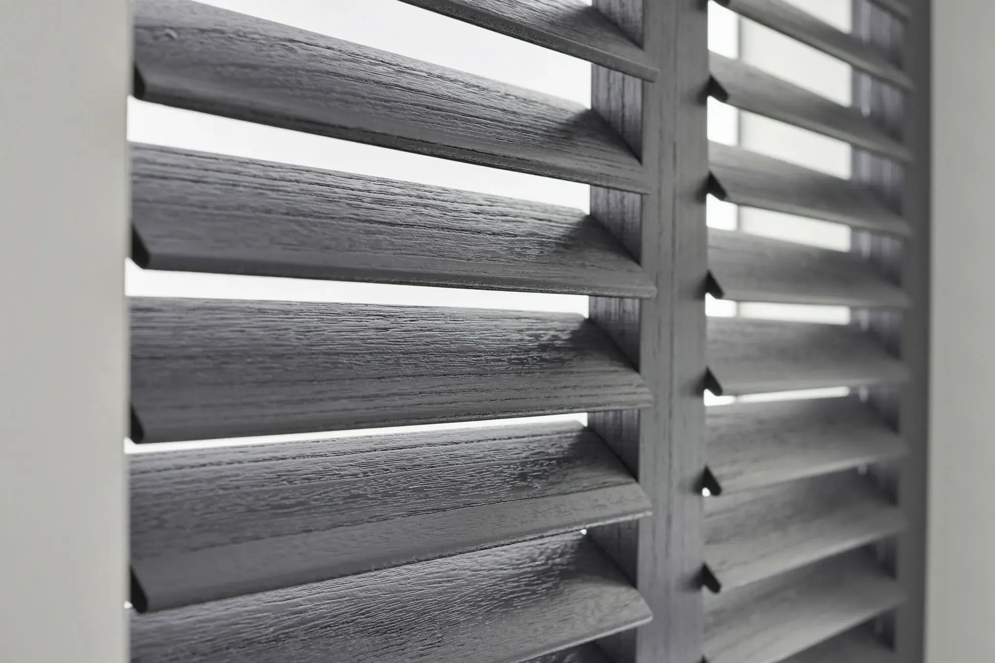 Detail van grijze shutters met houtnerf.