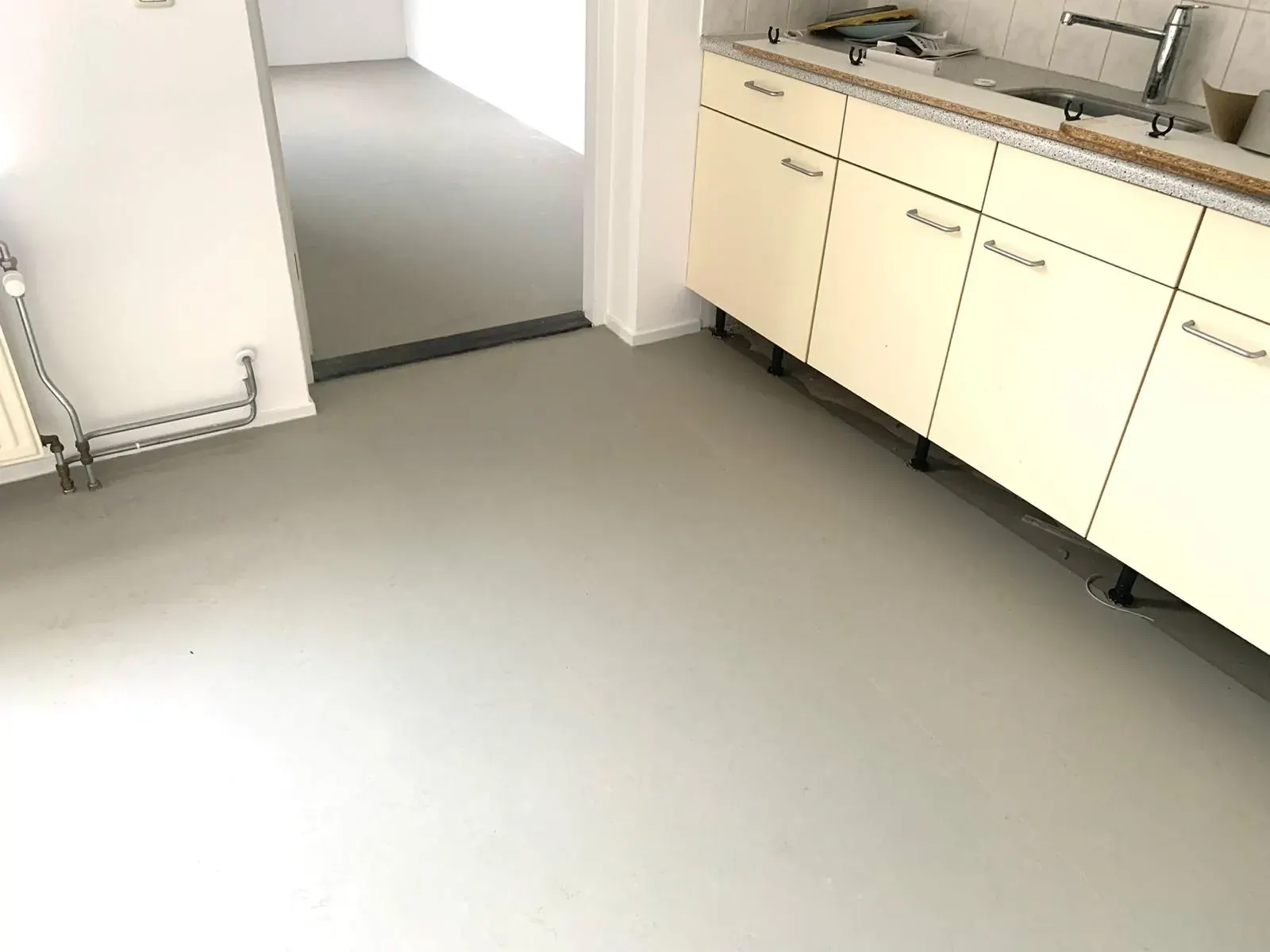 Lichtgrijze vinylvloer in een keuken.