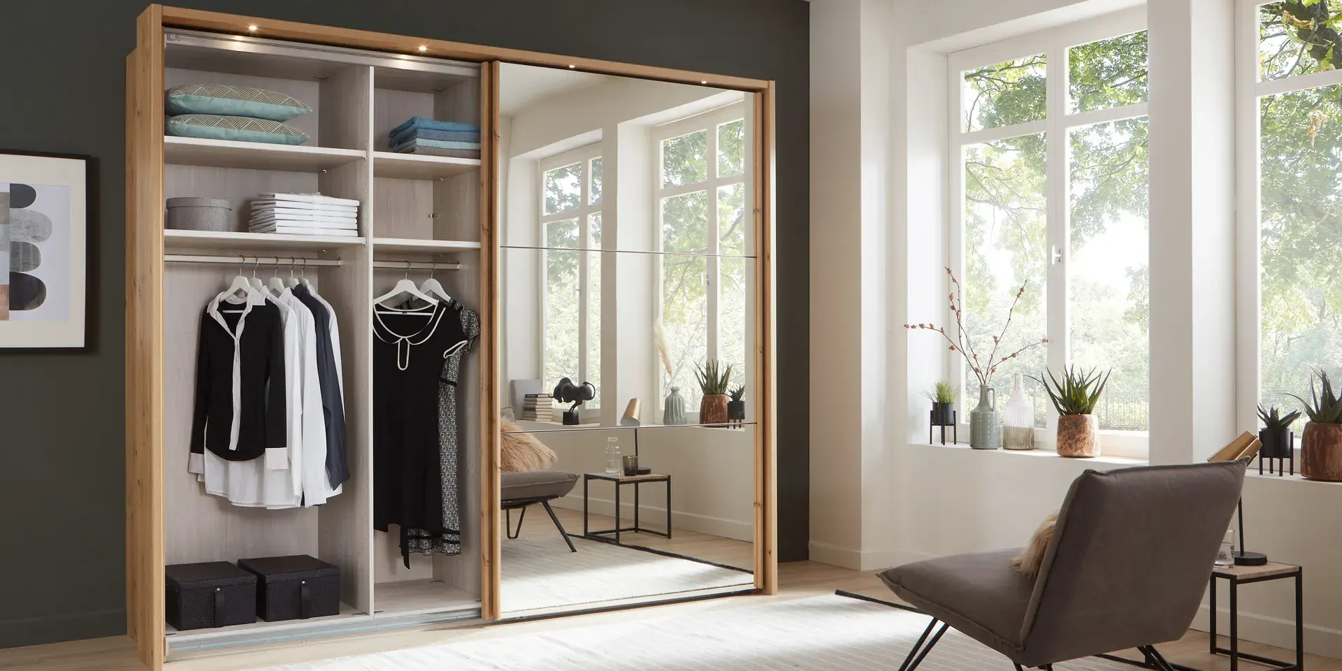 Schuifdeurkast van Wiemann, half open met kleding en legplanken.