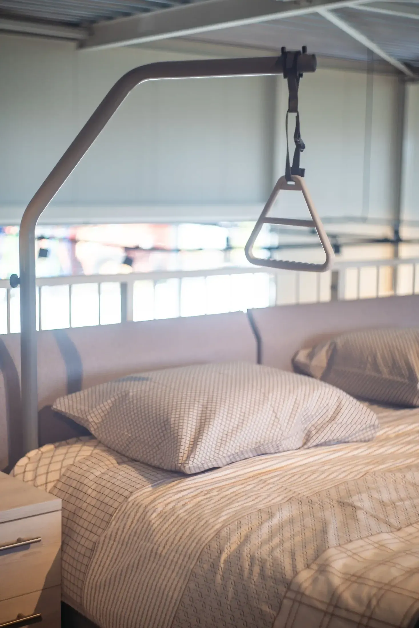 Zorgbed met papegaai en opgemaakt bed in de showroom.