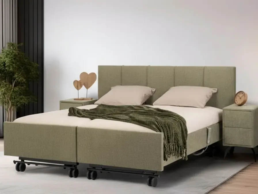 Tweepersoons zorgbed in groene stof met gestoffeerd hoofdbord.